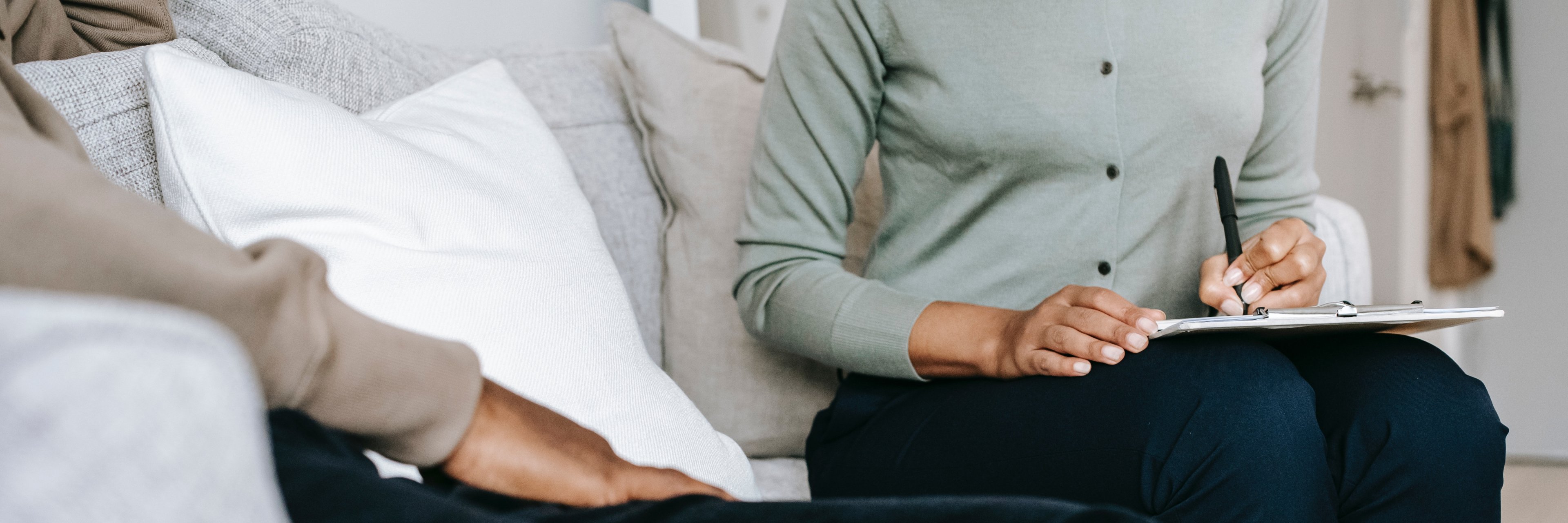 Gespräch von zwei auf einem Sofa sitzenden Personen 